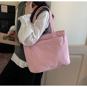 Detail view of pink quilted tote bag showing fine texture and puffy padded nylon surface