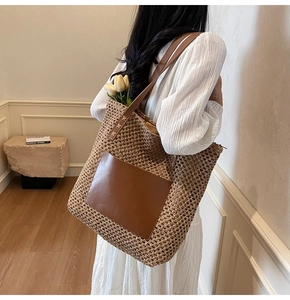 Detail of hand-woven straw tote bag featuring brown leather pocket and secure zipper closure