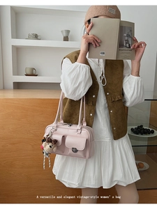 Detailed close-up of a pink vintage shoulder bag with dual front pockets and bear charm