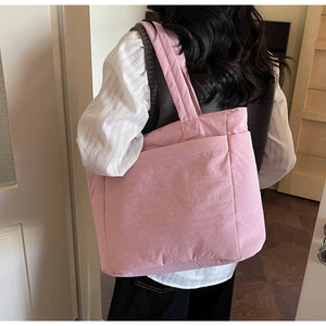 Rear view of a model wearing a pink quilted large-capacity tote bag for daily commute
