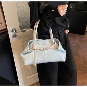 Détail du sac cabas élégant bicolore avec fines anses et sangle décorative à boucle
