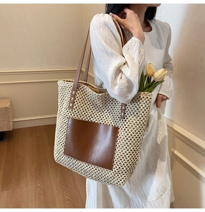 Detail of hand-woven straw tote with brown leather shoulder straps and vintage texture