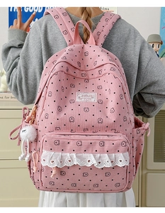 Detailed close-up of pink corduroy backpack with cute bear print and lace trim