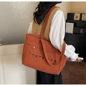 Vue détaillée du sac cabas en velours côtelé orange avec poche latérale et zip métallique