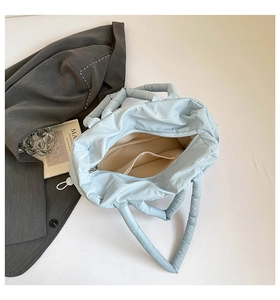 Top view of blue padded tote bag interior showing beige lining and zipper pocket details