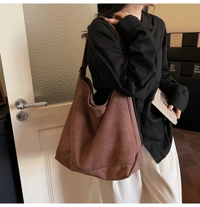 Detailed side view of a large brown suede tote bag showing its texture and capacity