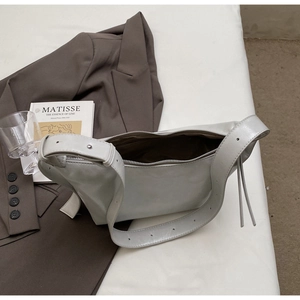 Detail view of leather crescent bag with silver zipper and wide adjustable shoulder strap