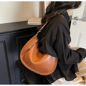 Detail view of caramel brown leather half-moon hobo bag with vintage gold stud embellishments