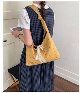 Polka dot canvas hobo bag in mustard yellow with a lace bow detail on the strap