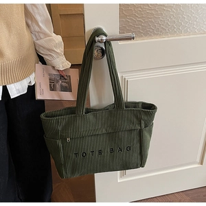 Détail du sac cabas en velours côtelé vert foncé montrant la texture et la poche zippée