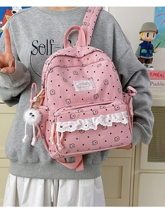 Detail of pink corduroy backpack with lace trim, polka dots and cute bear print pattern