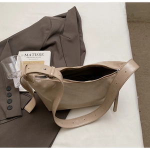 Detail view of beige minimalist hobo bag with adjustable strap and metal zipper