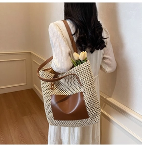 Back view of model carrying a large straw woven tote bag with brown leather pocket detail
