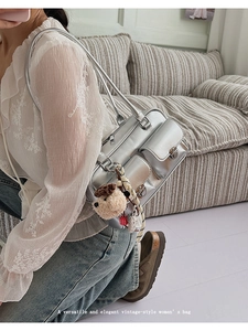 Silver metallic shoulder bag with utility pockets and a cute plush puppy pendant detail