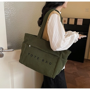 Détail du sac cabas en velours côtelé vert foncé avec broderie TOTE BAG noire