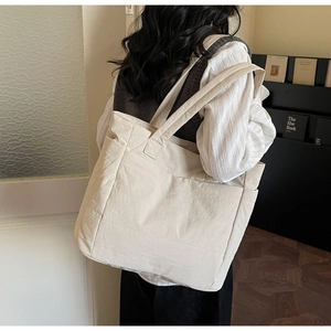 Close-up of off-white large capacity tote bag with practical pockets and soft texture