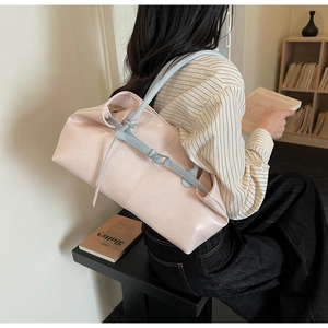 Détail du sac cabas en similicuir rose avec bandoulière bleue nouée sur l'épaule