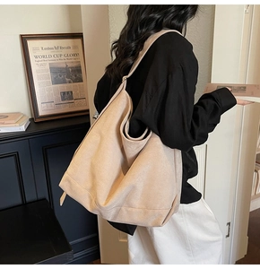 Detailed texture view of large beige suede hobo tote bag shown in a stylish retro interior