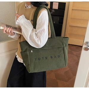 Détail du sac cabas en velours côtelé vert foncé avec texture et poche latérale