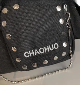 Close-up of canvas shoulder bag featuring silver rivets and CHAOHUO embroidery detail