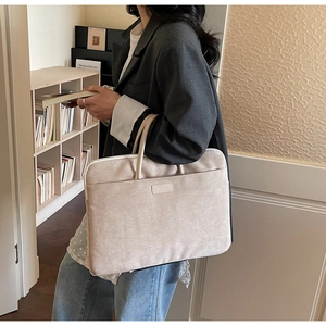 Modern beige laptop bag with front pocket shown in a professional lifestyle setting