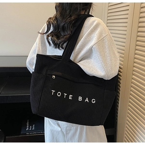 Détail du sac cabas en velours côtelé noir avec grande capacité et poche avant zippée