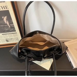 Vue détaillée de l'intérieur d'un sac cabas noir montrant poches et fermoir magnétique