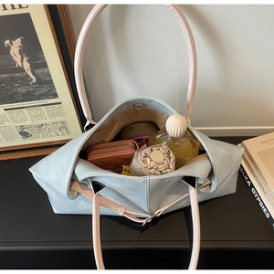 Vue de dessus de l'intérieur spacieux du sac cabas en cuir bleu clair avec anses roses et aimant