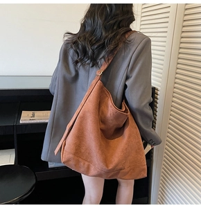 Caramel suede tote bag with a slouchy minimalist design shown on a model shoulder