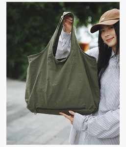 Détail du grand sac cabas vert olive avec compartiment zippé fonctionnel sur le fond