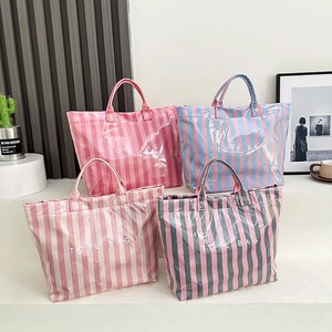 Détail de quatre sacs cabas rayés colorés avec finition brillante sur un présentoir