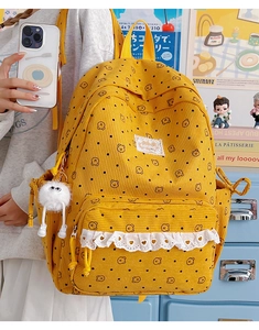 Close-up of yellow corduroy backpack with cute bear prints and white lace trim detail