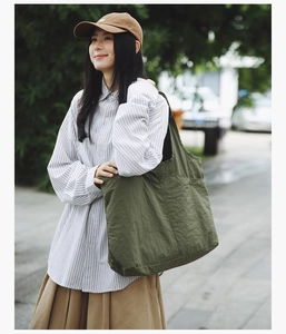 Sac fourre-tout en nylon vert olive avec poche latérale dans un cadre de vie extérieur
