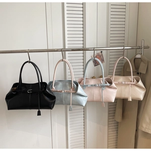 Détail de sacs fourre-tout en cuir en quatre couleurs suspendus sur une barre