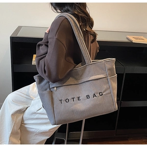 Détail du sac cabas en velours côtelé gris avec broderie et poche latérale pratique
