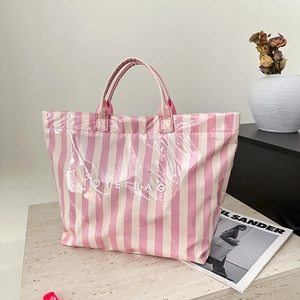 Détail du sac cabas à rayures roses et blanches montrant la texture brillante et l'espace