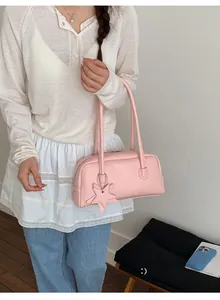 Gros plan détaillé d'un sac Boston rose avec un charmant pendentif étoile et anses