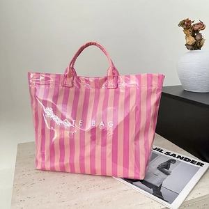 Détail du sac cabas à rayures roses avec surface brillante et lettrage blanc imprimé