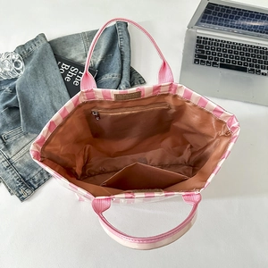 Vue interne montrant la doublure brune, poche zippée et compartiments du sac à rayures