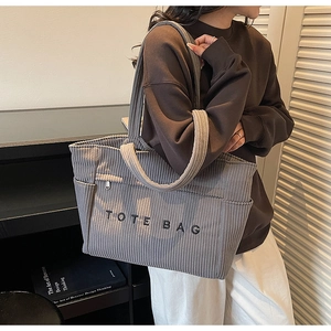 Texture détaillée du cabas en velours côtelé gris avec lettrage brodé noir tote bag