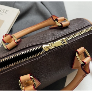 Detail of lychee pattern leather Boston bag with gold zipper and red edge oiling
