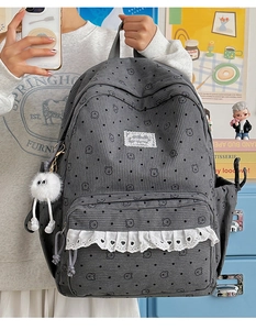 Detail view of grey corduroy backpack with cute bear print and white lace trim