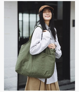 Détail du sac cabas vert olive avec poche latérale, boucle métallique et bandoulière