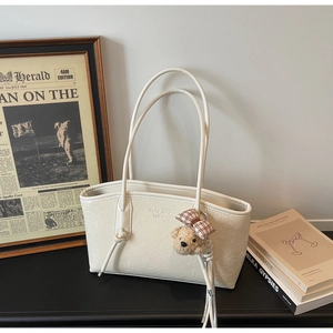 Elegante borsa tote beige in pelle increspata con un simpatico ciondolo a forma di orso