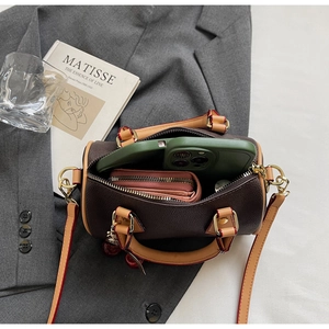 Top view of compact brown leather Boston bag showing interior storage capacity with phone