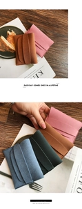 Macro detail of compact matte suede envelope wallets in pink, green, and blue colors