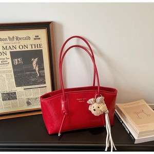 Borsa tote rossa lucida in ecopelle con spalline sottili e grazioso ciondolo a cucciolo