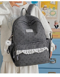 Close-up of dark grey corduroy backpack with cute cartoon bear print and lace detail