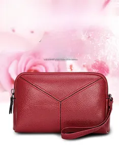 Close-up of elegant burgundy pebbled leather clutch bag with stylish black stitching