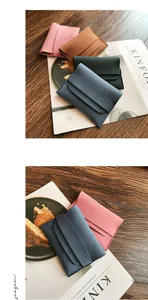 Minimalist frosted leather coin purses in four colors on a wooden table with magazines